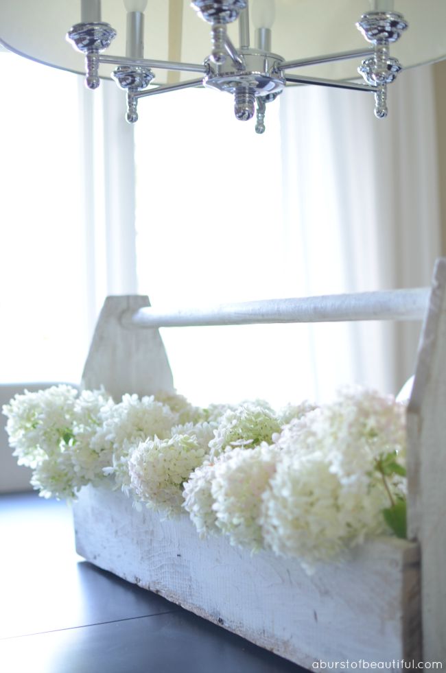 A vintage wood toolbox filled with white hydrangeas is the perfect summer centre-piece for your dining table | A Burst of Beautiful 